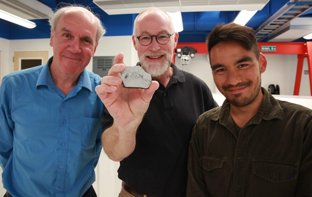 Paul Warren, Edward Young and Issaku Kohl. Young is holding a sample of a rock from the moon.