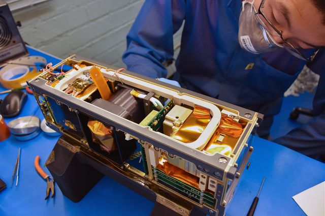Photo of Ethan Tsai working on flight model assembly