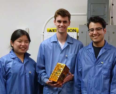 Bruin Space team members Chloe Liau, Andrew Evans, and Alexander Gonzalez holding their final flight model.