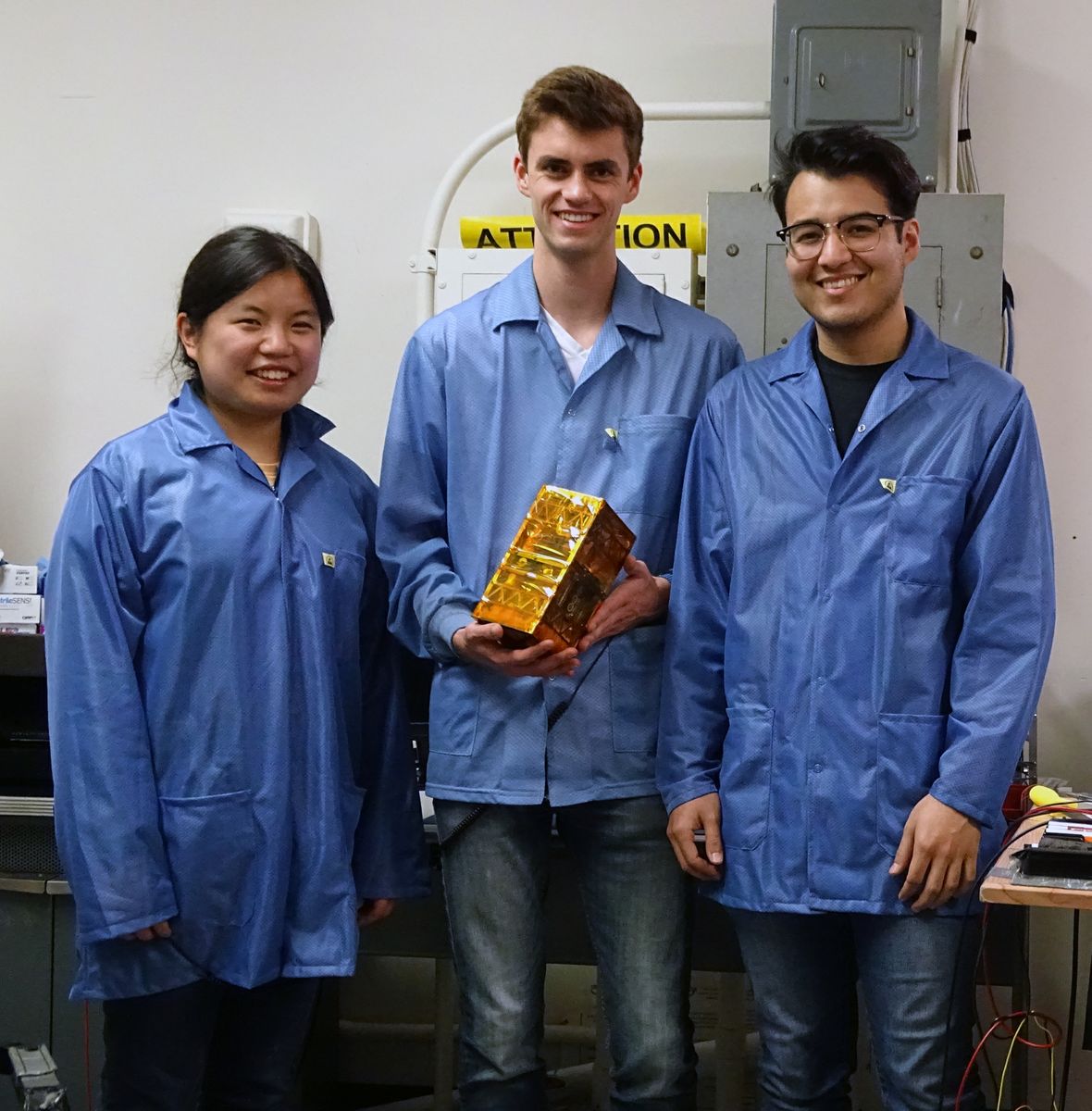 Bruin Space team members Chloe Liau, Andrew Evans, and Alexander Gonzalez holding their final flight model.