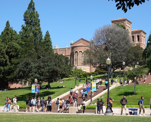 A photo of students on the UCLA campus, with the Janss Steps and Royce Hall in the background.