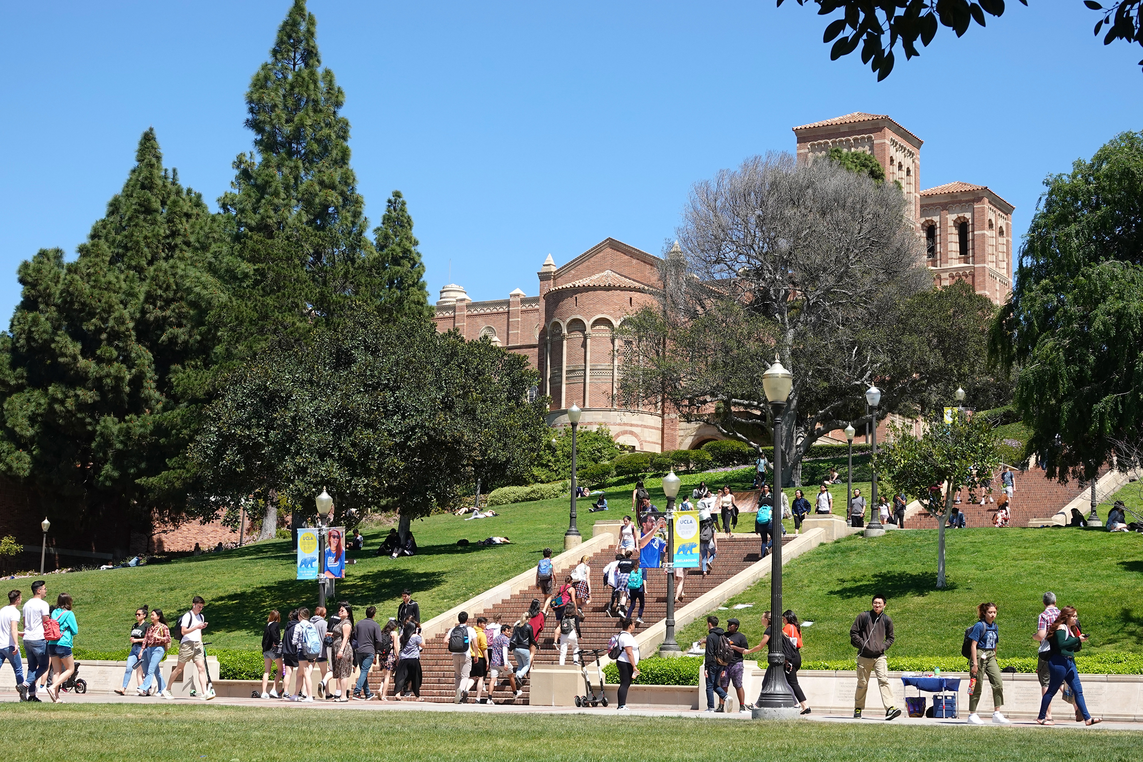 A photo of students on the UCLA campus, with the Janss Steps and Royce Hall in the background.