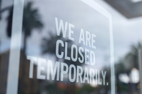 A photo of a storefront with a sign that says "We are closed temporarily."