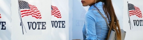 A photo of a woman at a voting booth.