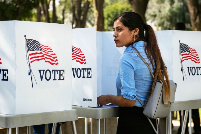 Woman+at+a+voting+booth_mid A photo of a woman at a voting booth.