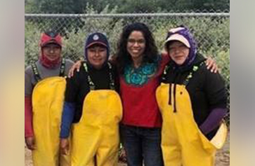 A photo of Gaye Theresa Johnson, meeting with cilantro workers.