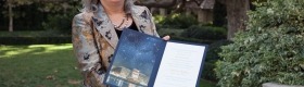 A photo of Andrea Ghez receiving her Nobel Prize citation and medal.