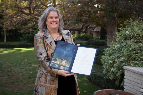 A photo of Andrea Ghez receiving her Nobel Prize citation and medal.