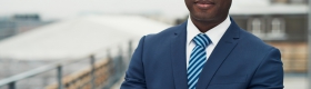 A photo of a Black man in suit and tie.