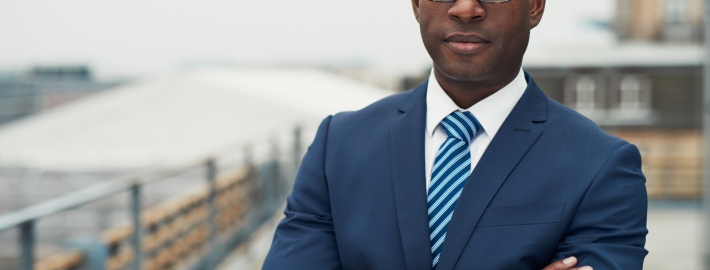 A photo of a Black man in suit and tie.