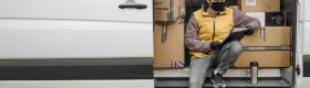 A photo of a worker wearing a face covering on a delivery truck.