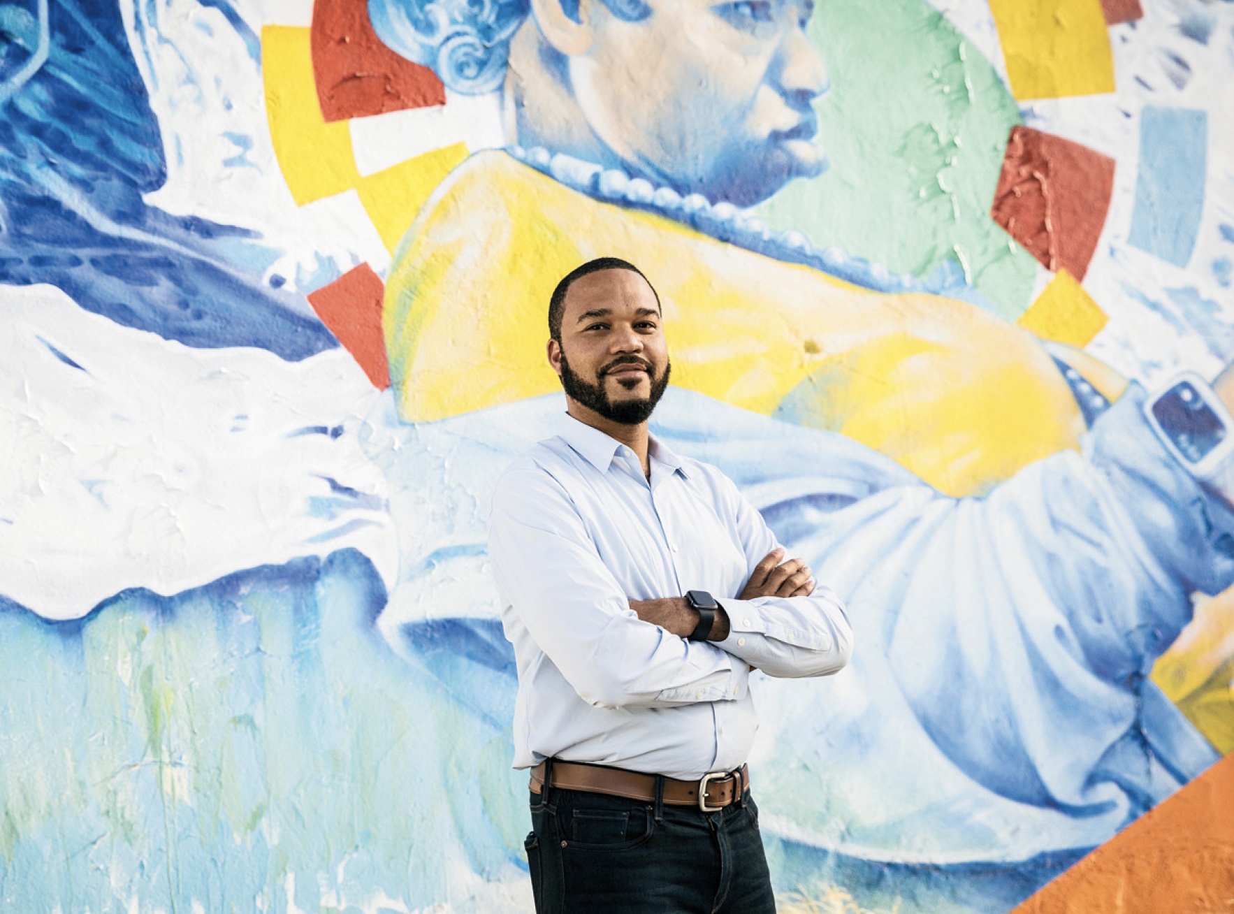 A photo of D’Artagnan Scorza in front of mural.