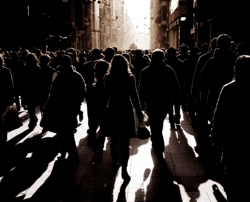 silhouetted people walking on busy street. iStock.com/imagedotpro
