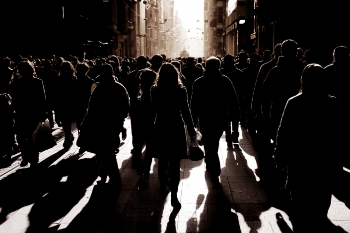 crowded people walking on busy street silhouetted people walking on busy street. iStock.com/imagedotpro