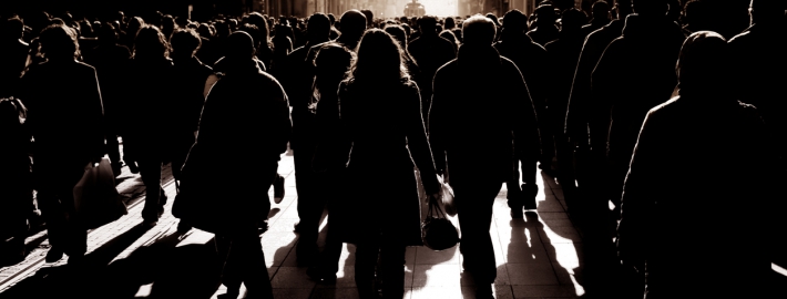 silhouetted people walking on busy street. iStock.com/imagedotpro