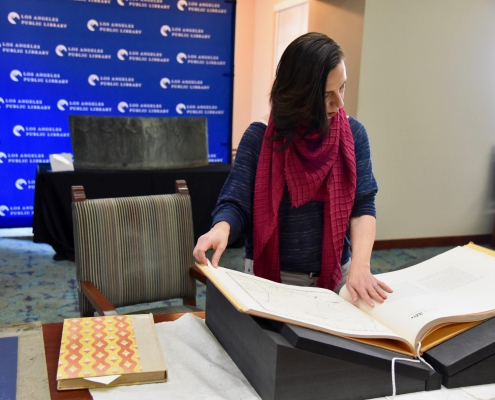 Professor Marissa López examines Robert Becker’s "Diseños of California Ranchos: Maps of thirty-seven Land Grants if 1822-1846 from the Records of the United States District Court, San Francisco" in the Rare Books room at Central Library downtown. PHOTO CREDIT: Yvonne Condes