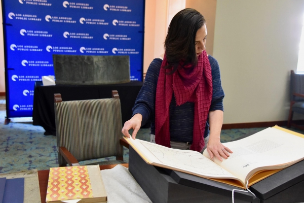 Professor Marissa López examines Robert Becker’s "Diseños of California Ranchos: Maps of thirty-seven Land Grants if 1822-1846 from the Records of the United States District Court, San Francisco" in the Rare Books room at Central Library downtown. PHOTO CREDIT: Yvonne Condes