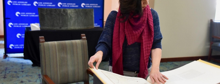 Professor Marissa López examines Robert Becker’s "Diseños of California Ranchos: Maps of thirty-seven Land Grants if 1822-1846 from the Records of the United States District Court, San Francisco" in the Rare Books room at Central Library downtown. PHOTO CREDIT: Yvonne Condes