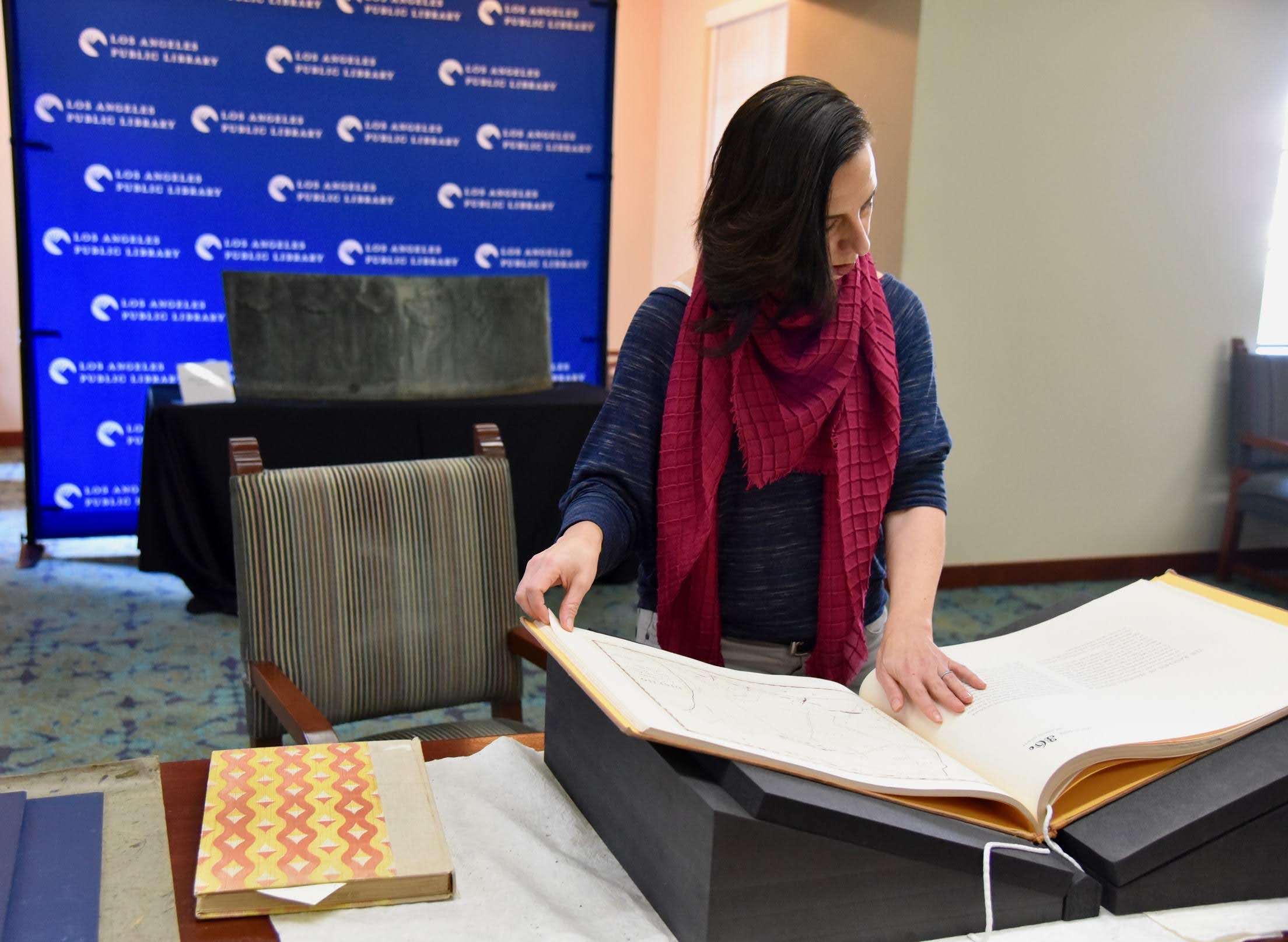 Professor Marissa López examines Robert Becker’s "Diseños of California Ranchos: Maps of thirty-seven Land Grants if 1822-1846 from the Records of the United States District Court, San Francisco" in the Rare Books room at Central Library downtown. PHOTO CREDIT: Yvonne Condes