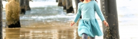 Evangelina Vaccaro playing beneath pier at the beach