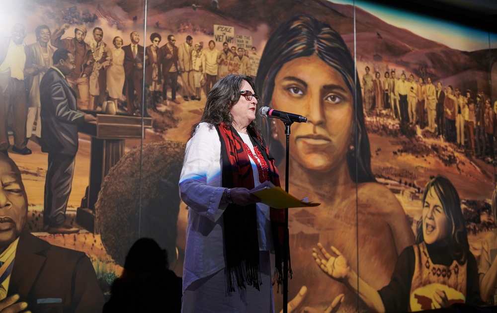 Image of Judith Baca, UCLA professor emeritus of Chicana and Chicano and Central American studies and of world arts and cultures, at the unveiling of her mural “La Memoria de la Tierra: UCLA.” Image credit: Don Liebig/ASUCLA