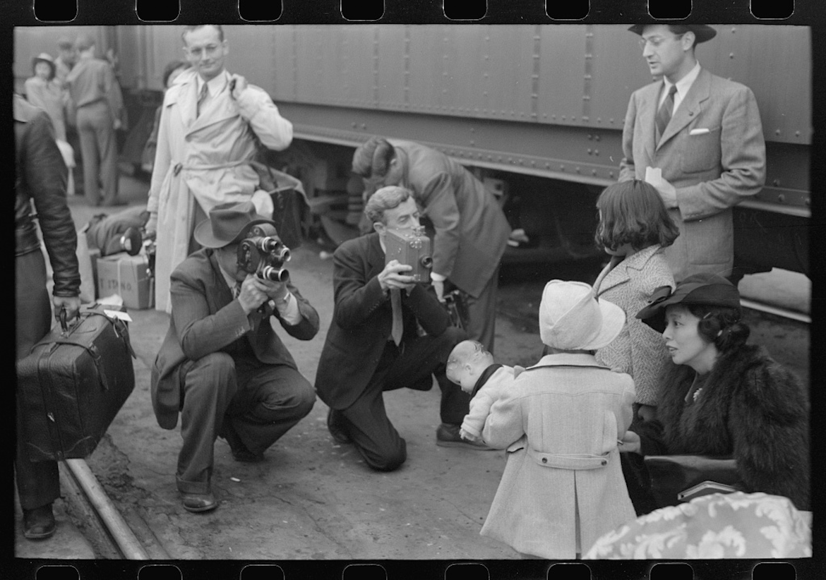 Historic image of cameramen recording Michi Tanioka, 5, as she waits to be sent from Los Angeles to the Manzanar prison camp in April 1942. 