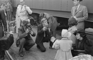 Historic image of cameramen recording Michi Tanioka, 5, as she waits to be sent from Los Angeles to the Manzanar prison camp in April 1942.