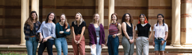 Portrait of nine members of the Society of Gender Equity in Geosciences at standing in front of Royce Hall