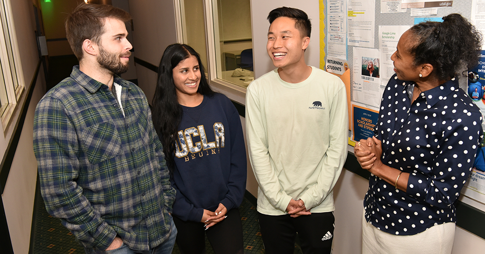 Image of four people (Angela Deaver Campbell and three UCLA students) standing together and talking.