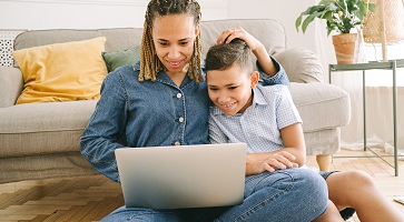 Woman and boy on floor with laptop