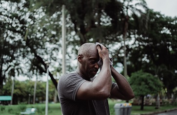 Person wiping sweat off brow