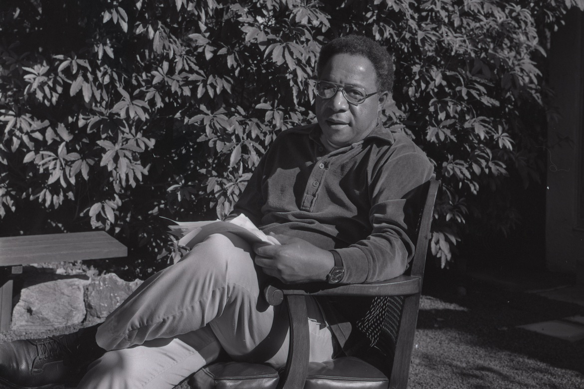 Alex Haley seated in chair in backyard, surrounded by foliage