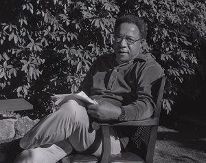 Alex Haley seated in chair in backyard, surrounded by foliage