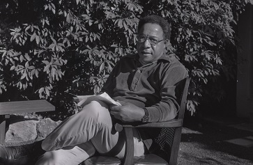 Alex Haley seated in chair in backyard, surrounded by foliage