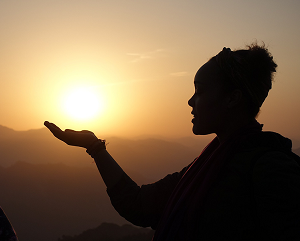 CSSE-363 A silhouette of a person with a hand outstretched in front of a golden sunset