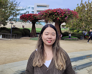 Gloria Jiyoon Kim at the Getty Center, with trees and building in the background