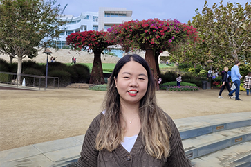 Gloria Jiyoon Kim at the Getty Center, with trees and building in the background