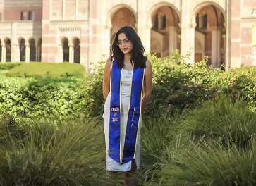 Samantha Gallegos wearing a white dress and blue graduation sash.