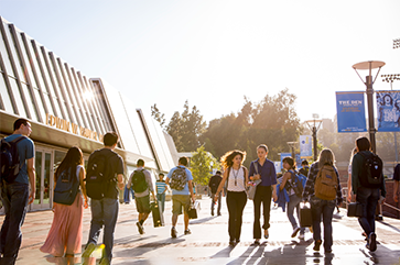 Students on Bruin Walk pass the north entrance to Pauley Pavilion.