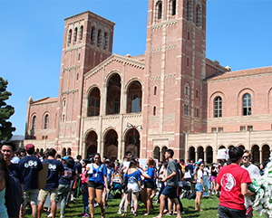 Students gathered in front of Royce Hall on sunny day with a clear blue sky.