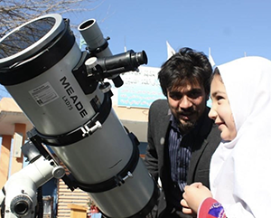 Abraham Amiri with young girl and a telescope