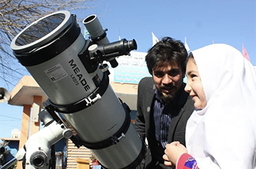 Abraham Amiri with young girl and a telescope