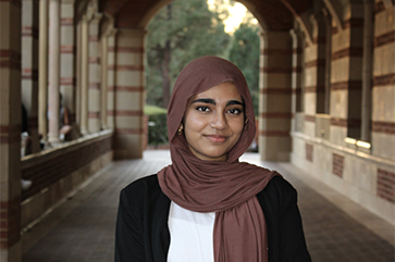 Tasnim Jahan standing in the stone corridor of Royce Hall