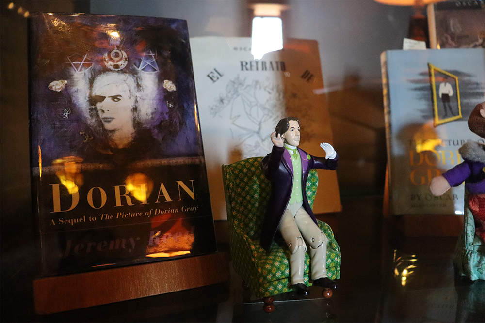 A display of an Oscar Wilde figurine, a copy of "Dorian: A Sequel to The Picture of Dorian Gray," and other Oscar Wilde memorabilia.
