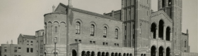 A black and white photograph taken in the 1930s depicting students walking across the Royce Hall Terrace, books in hand.