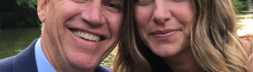 A head and shoulders of (from left to right) Matthew C. Harris and Jennifer Harris, an alumnus, with trees and flowing water in the background.
