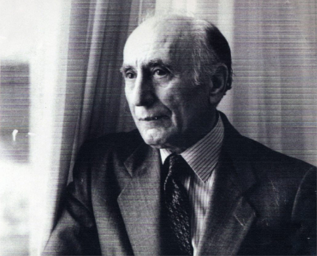 A black and white head and shoulders photograph of Ehsan Yarshater wearing a suit and tie and leaning against a window with curtains. Yarshater (1920–2018), served as the Hagop Kevorkian Professor of Iranian Studies at Columbia University and was a towering figure in the field.