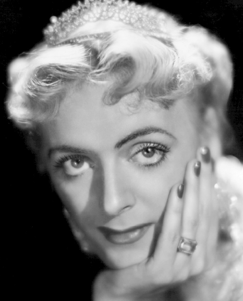 A black and white photograph of Christine Jorgensen resting her head on her hand.