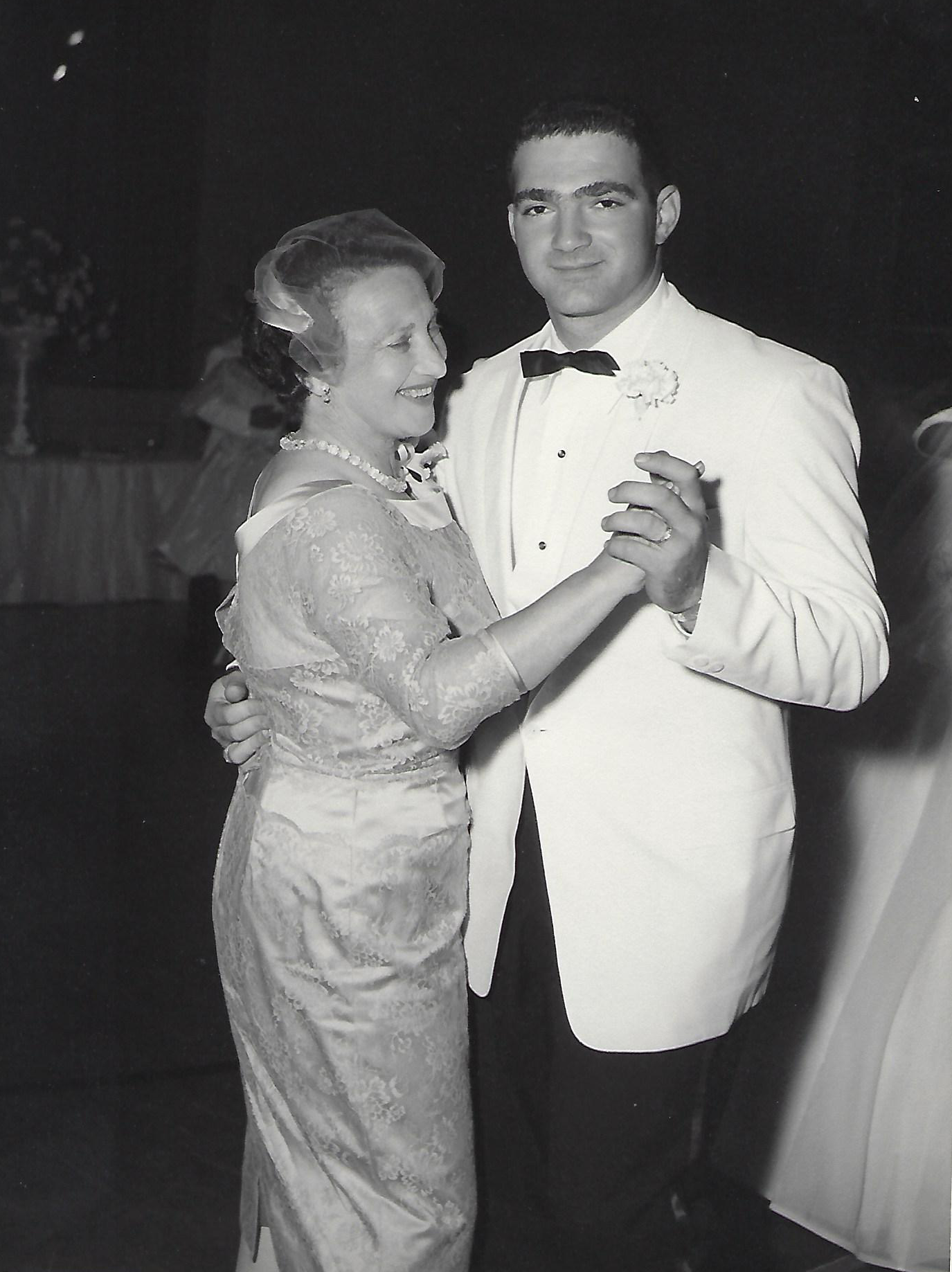 A black and white photograph of Sidney Blumner in formal attire dancing with a woman in a dress.