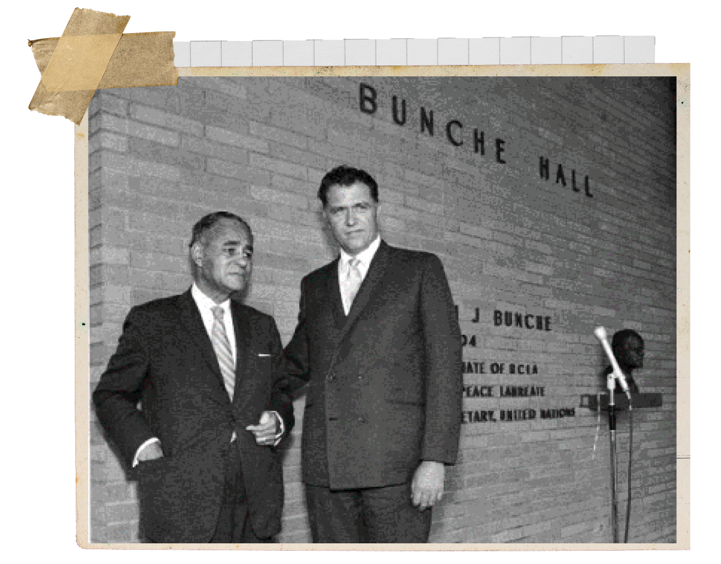 A black and white photography of Ralph Bunche with a man in a suit in front of "Bunche Hall," a building named in honor of him on 1969.